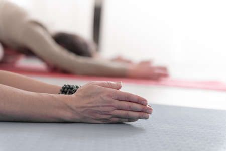 Close-up of feminine and masculine arms during meditation.  Shashankasana position. Rabbit Pose. Seguence of Surya namaskar. Greeting to the Sun. How to Keep Your Arms for a Kriya or Meditation.の写真素材