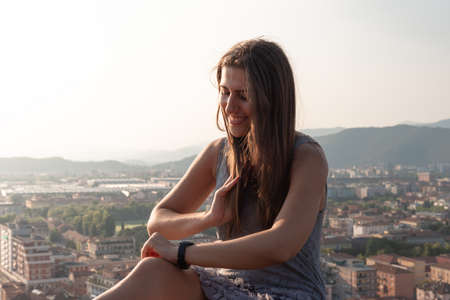Woman on the roof terrace with aerial view of the old Italian city Brescia at sunset.の写真素材