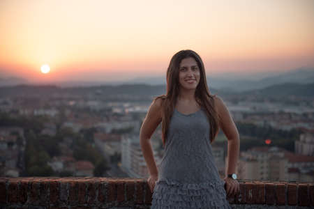 Woman on the roof terrace with aerial view of the old Italian city Brescia at sunset.の写真素材