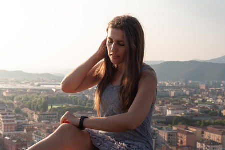 Woman on the roof terrace with aerial view of the old Italian city Brescia at sunset.の写真素材