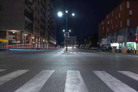 Timelapse view of traffic at an urban night intersection. Urban movement in the Italian city in the evening.Time Lapse.の写真素材