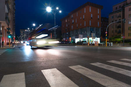 Timelapse view of traffic at an urban night intersection. Urban movement in the Italian city in the evening.Time Lapse.の写真素材