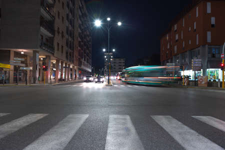 Timelapse view of traffic at an urban night intersection. Urban movement in the Italian city in the evening.Time Lapse.の写真素材