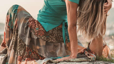 Adult woman does sports exercise. Yoga teacher doing an asana on the old city wall.の写真素材