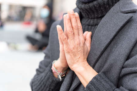 Yoga teachers protesting against the blockade and restrictions of Covid-19 in a square in Brescia, Italy. Female and male hands in a namaste or prayer gesture.の写真素材