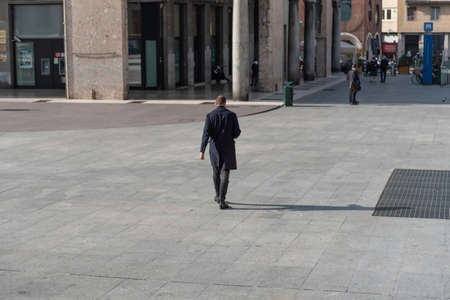 Man walking in the city wearing a medical mask to prevent covid-19のeditorial素材