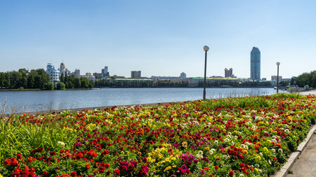 Flowerbed with bright multicolored flowers on embankment of city pond of Iset River, Yekaterinburg, Russia.の写真素材
