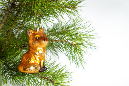 Glass Christmas tree toy red fox with glitter hangs on the branches of a New Year tree on a white background. Copy space or place for text. The basis for a postcard or congratulations.の写真素材
