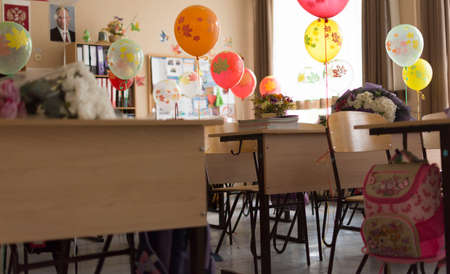 Cute little girl sitting at the table with balloonsの写真素材
