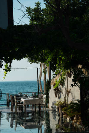 Tables and chairs in a restaurant on the shore of the Mediterranean Seaの写真素材