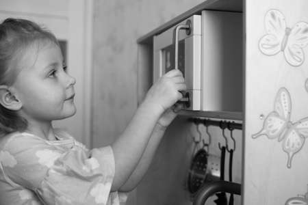 Cute little girl playing in the kitchen.の写真素材