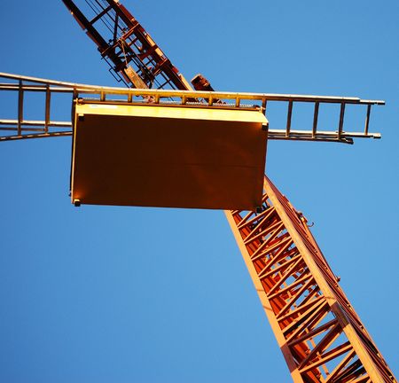 Square shot of orange crane on blue skyの写真素材
