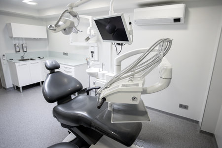 Dental equipment in dentist office in new modern stomatological clinic room. Background of dental chair and accessories used by dentists in grey and whiteの写真素材