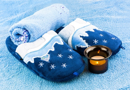 Slippers with blue towels and candle in candlestickの写真素材