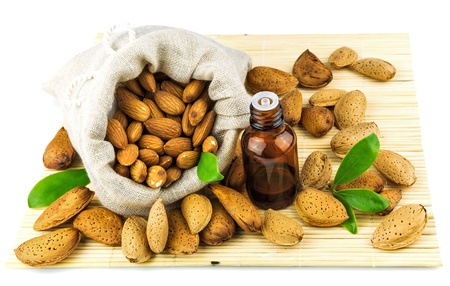 Almonds in the sack and almond oil on mat isolated on white backgroundの写真素材