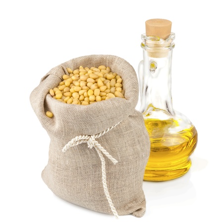 Macro view of pine nuts in flax sack and glass bottle of oil isolated on white backgroundの写真素材