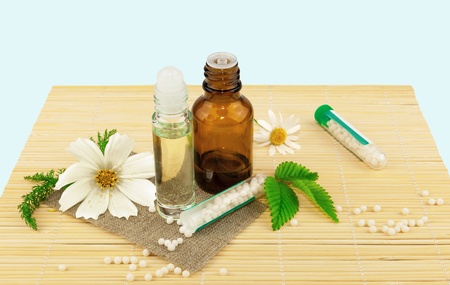 Homeopathic medication with flowers and leaves on the matの写真素材