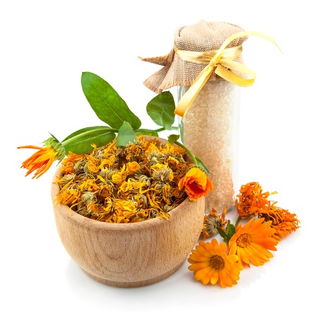 Bowl with flowers of marigold and sea salt isolated on white backgroundの写真素材