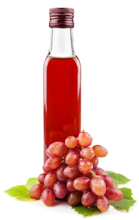 Glass bottle of wine vinegar with a bunch of grapes isolated on white backgroundの写真素材