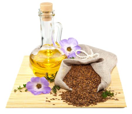 Macro view of flax seeds in flax sack and glass bottle of flax oil isolated on white backgroundの写真素材