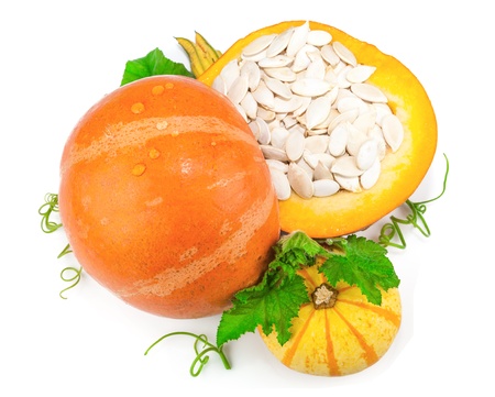 Pumpkin with pumpkin seeds and green leaves isolated on white backgroundの写真素材
