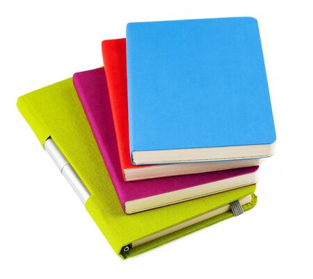 Colourful notebooks with open notebook and ballpoint pen isolated on white backgroundの写真素材