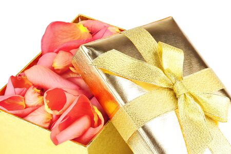 Golden box full of roses petals isolated on white backgroundの写真素材