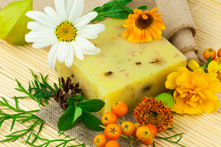 Macro view of natural soap, berries and flowers on the matの写真素材