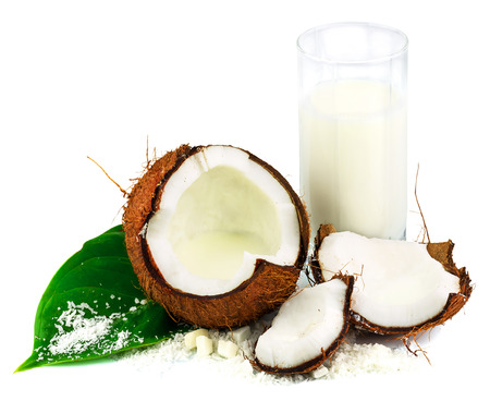 Coconut with glass of coconut milk and green leaf isolated on white backgroundの写真素材