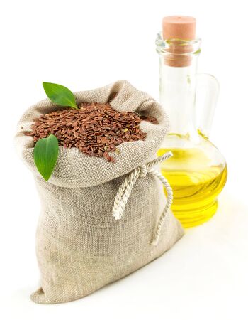 Macro view of flax seeds in flax sack with leaves and glass bottle of flax oil isolated on white backgroundの写真素材