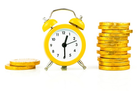 Clock with coins, time is money isolated on white backgroundの写真素材