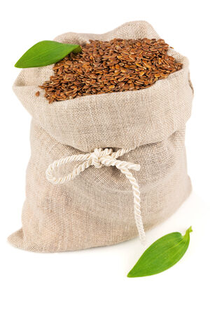 Macro view of flax seeds in flax sack with leaves isolated on white backgroundの写真素材