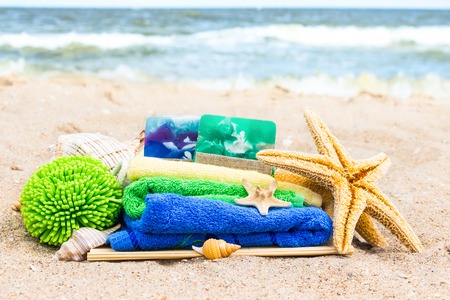 Day at the beach with towels, soap, seashells and starfishの写真素材