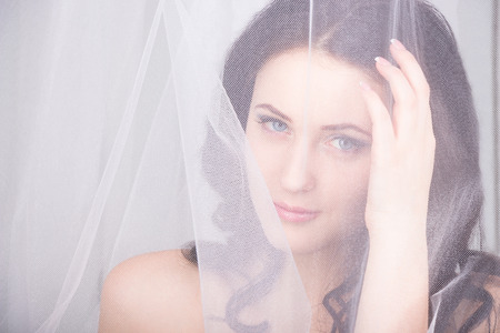 Young girl with blue eyes behind a bridalの写真素材