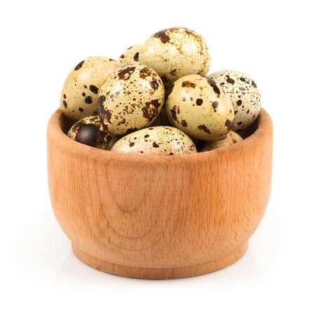 Quail eggs in a wooden bowl isolated on white backgroundの写真素材