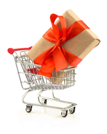 Gift with red bow in the shopping cart isolated on white backgroundの写真素材