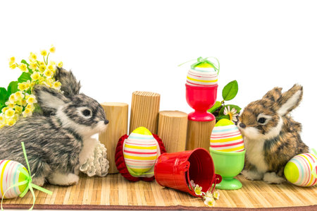 Composition from rabbits, easter eggs and flowers on the mat isolated on white backgroundの写真素材