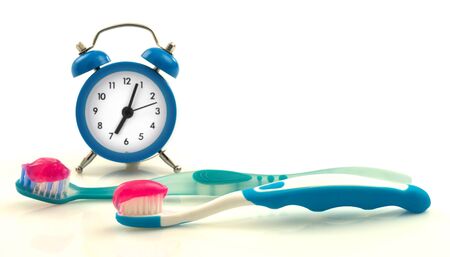 Composition from blue clock and toothbrushes with magenta toothpasteの写真素材