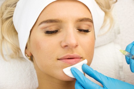 Young woman face, injection, hands with medical gloves, beauty treatmentの写真素材