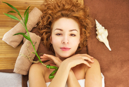 Spa concept with beautiful young woman, shell, bamboo and towelsの写真素材