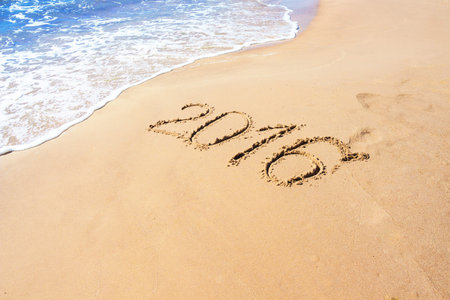 Number 2016 year on the sand sea shore, summer background