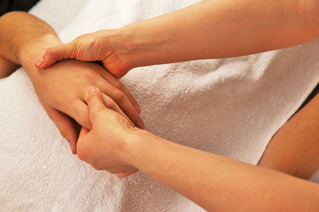Hand massage with white towelの写真素材