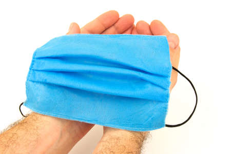 Male hands with cloth protective mask on white backgroundの写真素材