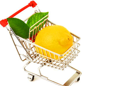 Macro view of lemon with green leaves in metal trolley on white backgroundの写真素材