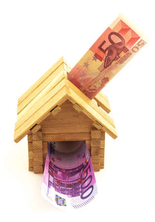 Wooden toy house with euro paper money isolated on white backgroundの写真素材