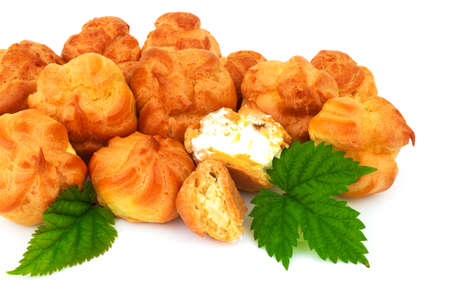 Macro view of group yellow baked eclair, custard, cake, profiterole, bread with green leaves. Isolated on white background.の写真素材