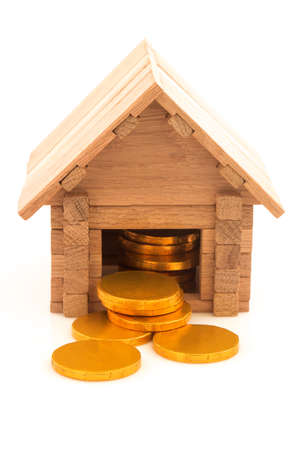 Wooden toy house with chocolate candy golden coins Isolated on white background.の写真素材