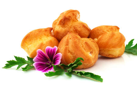 Tasty eclair, custard, cake, profiterole with violet flower. Isolated on white background.の写真素材