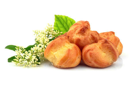 Tasty eclair, custard, cake, profiterole with fresh white morning flower. Isolated on white background.の写真素材