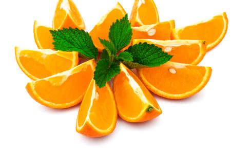 Macro view of orange with slices and fresh green leaf of mint on white backgroundの写真素材